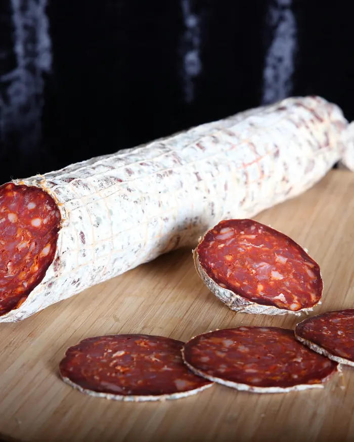 Saucisson sec entamé, tranches sur planche